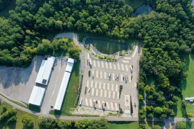 Aerial view of Lakeside Oasis RV Park near Lake Cumberland in Albany, Kentucky, showing the concrete pads, pond and wooded surroundings